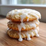 A stack of three soft maple brown sugar cookies generously drizzled with white glaze.