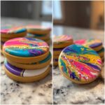 Close-up of round sugar cookies topped with vibrant, marbled sugar cookie icing that hardens, decorated with sprinkles.