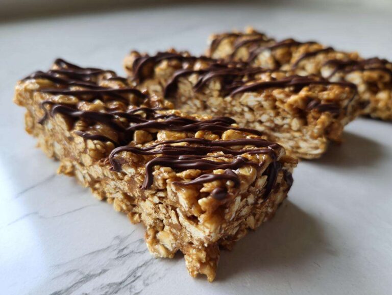 Close-up of homemade protein bars made with oats, drizzled generously with dark chocolate.