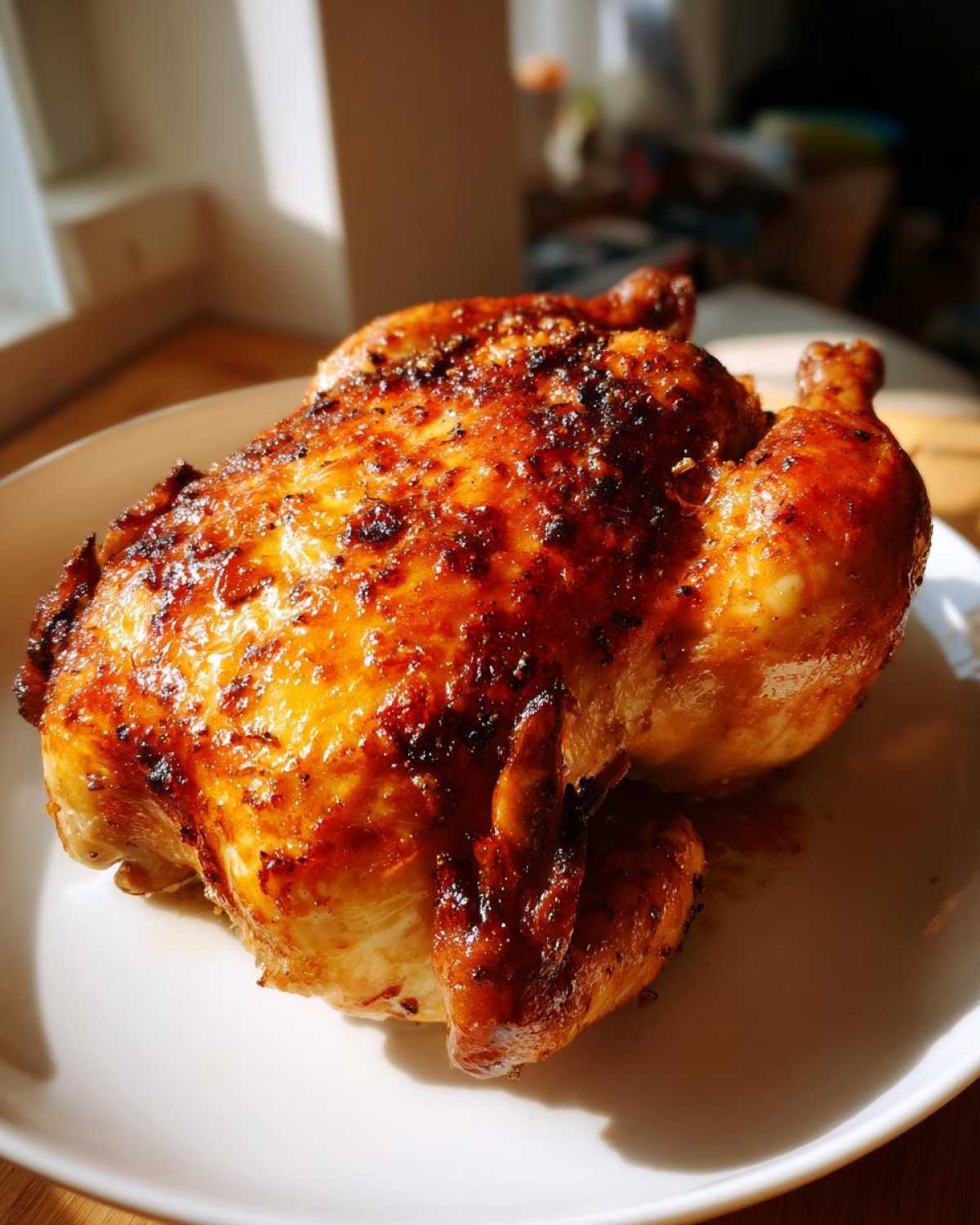 A whole chicken, perfectly roasted with crispy, browned skin, ready to serve after being cooked as an air fryer whole chicken.