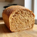 Close-up of a freshly baked whole wheat bread loaf, showing the soft, open crumb texture.