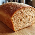 Close-up of a freshly baked whole wheat bread loaf showing the soft, airy crumb texture.