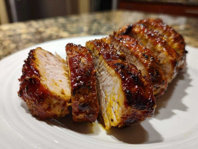 Close-up of thick, sliced baked ranch chicken with a glossy, caramelized exterior.