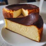A creamy slice of basque burnt cheesecake with a dark caramelized top resting on a white plate.