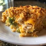 Close-up of a serving of creamy Chicken Divan showing shredded chicken, broccoli, and a golden, crunchy topping.