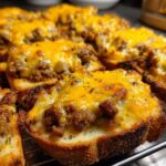 Close-up of a cheesy hanky panky recipe appetizer on toasted bread with seasoned ground meat topping.