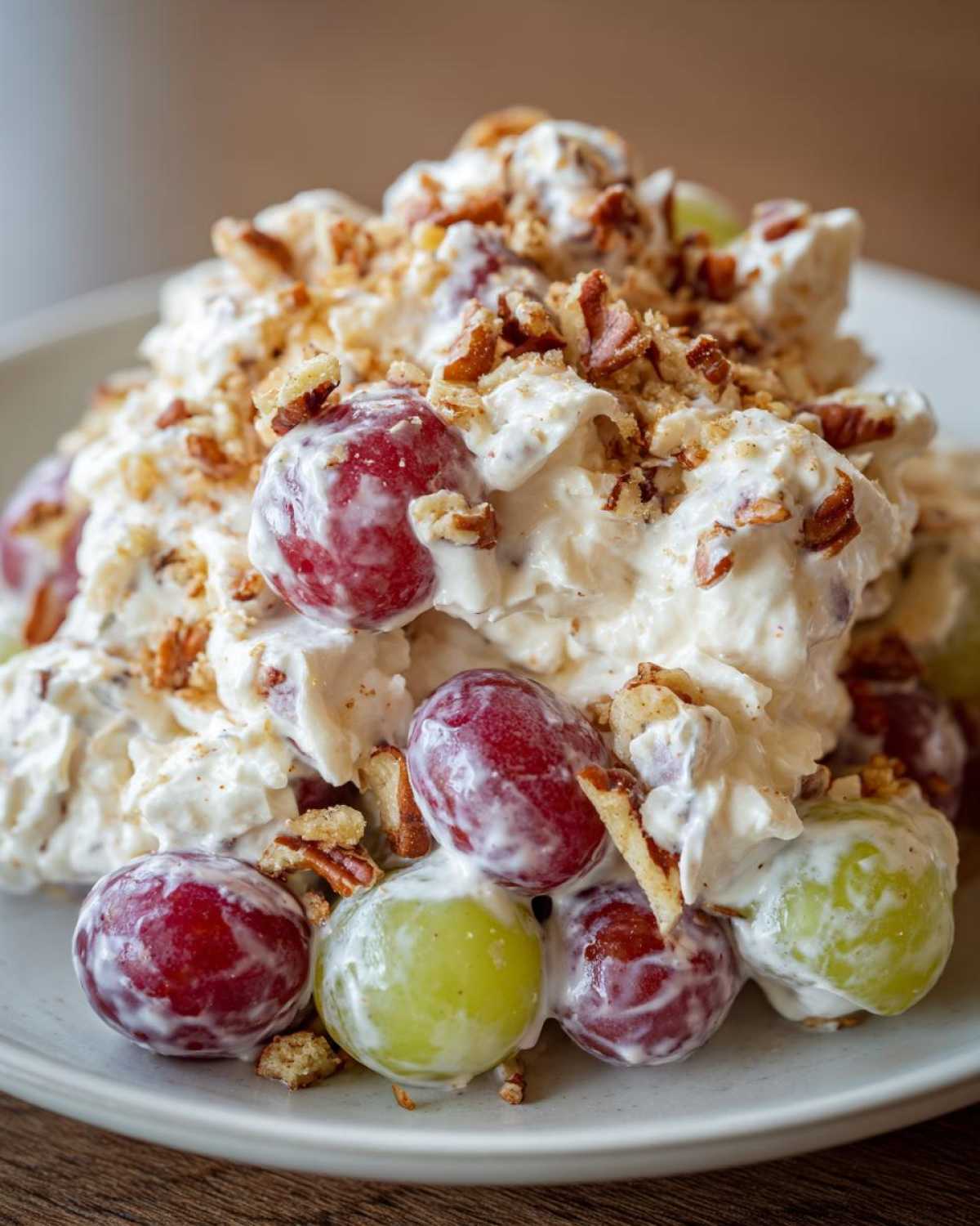Close-up of creamy chicken salad chick grape salad topped with chopped pecans.