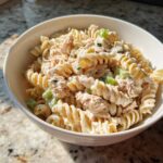 Close-up of creamy Tuna Pasta Salad made with rotini pasta, tuna, and celery in a white bowl.