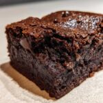 Extreme close-up of a fudgy, dark chocolate sweet potato brownies square showing melted chocolate chips.