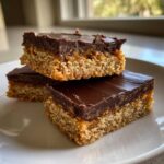 Three stacked squares of graham cracker toffee featuring a thick chocolate top layer and gooey caramel.