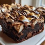 A rich, fudgy hot chocolate brownie square topped with toasted marshmallows and a chocolate drizzle.
