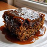 Close-up of a square slice of moist sticky toffee pudding recipe covered in rich caramel sauce.