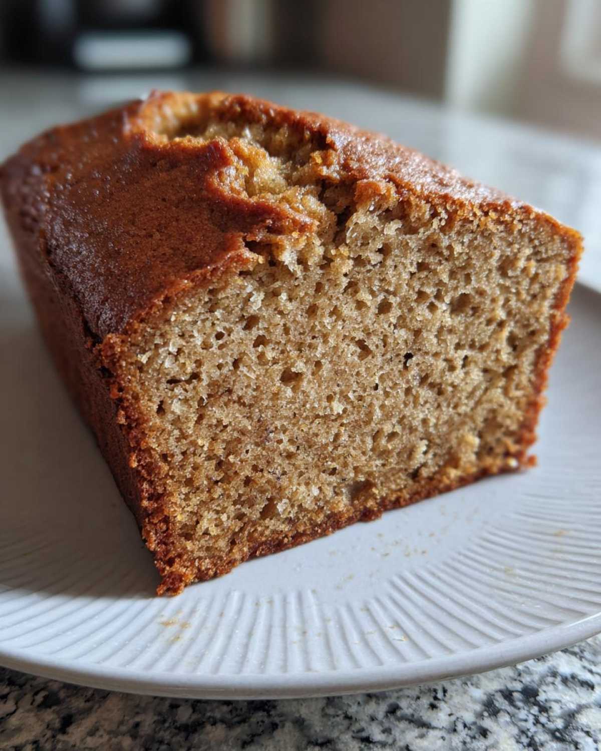 A close-up of a moist slice of sugar free banana bread showing its soft crumb texture.