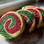 Close-up of sliced red, green, and white pinwheel cookies showing a vibrant swirl pattern.