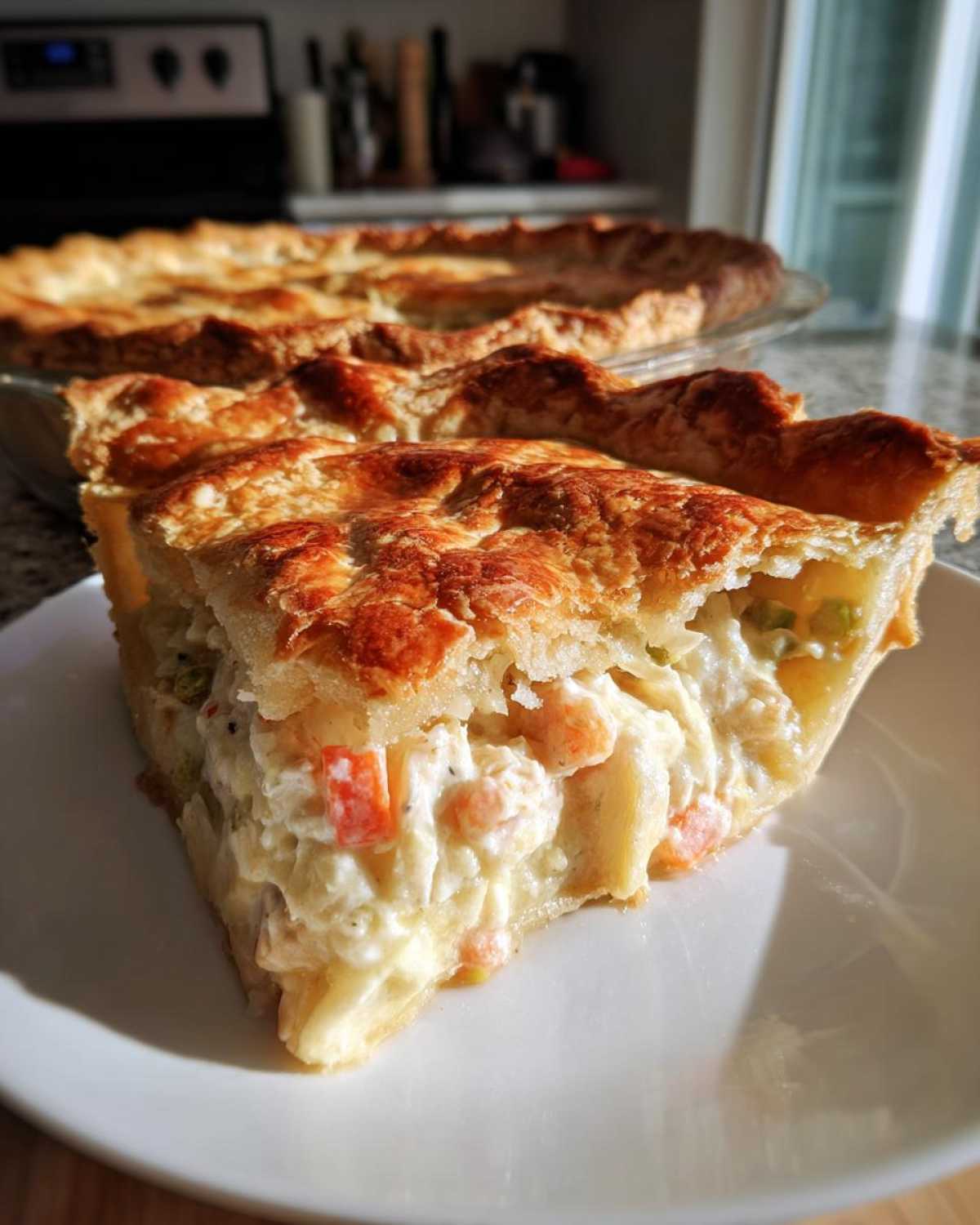 A generous slice of turkey pot pie recipe showing creamy filling and golden, flaky crust.