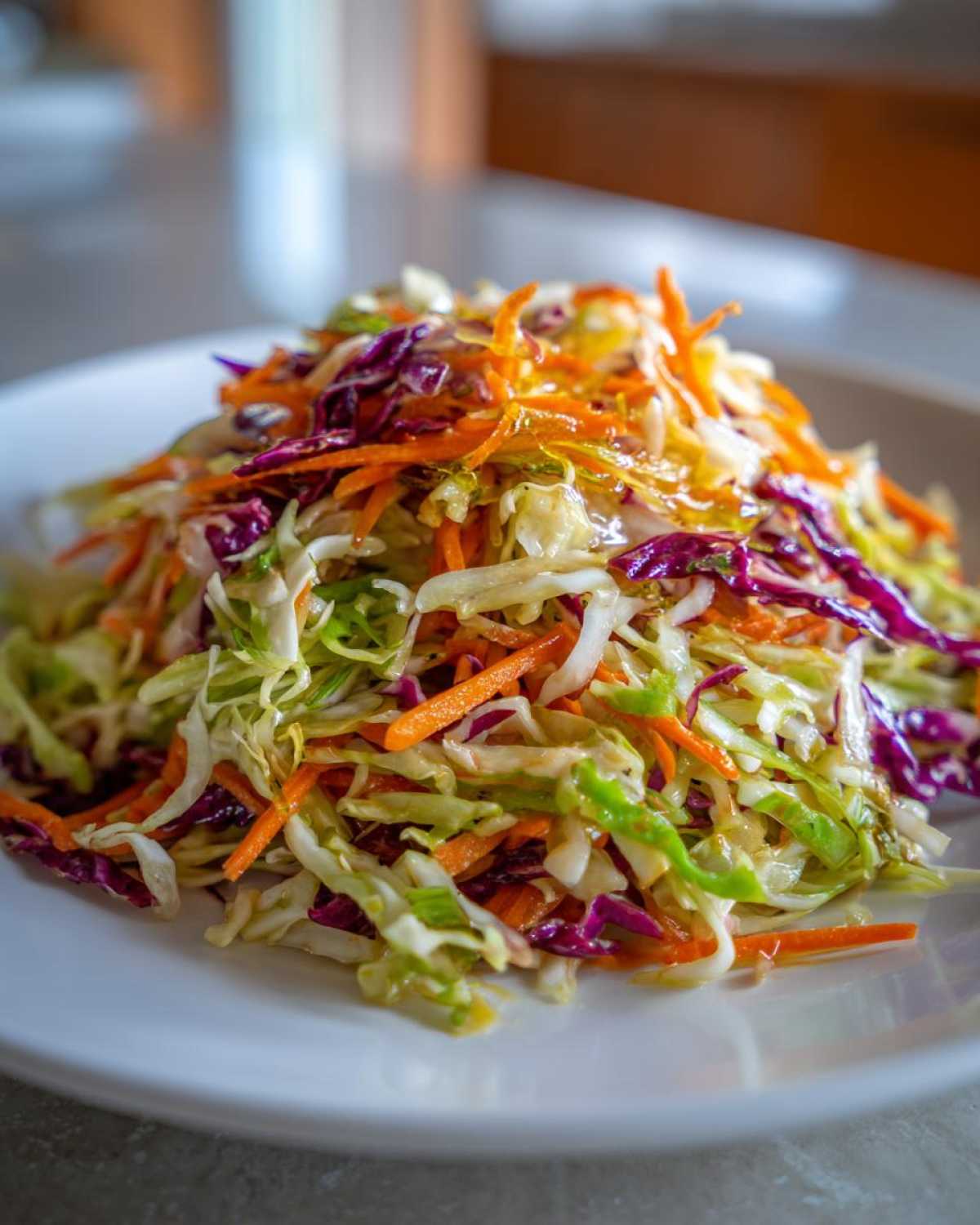 Close-up of a vibrant cabbage salad featuring shredded green cabbage, red cabbage, and carrots.