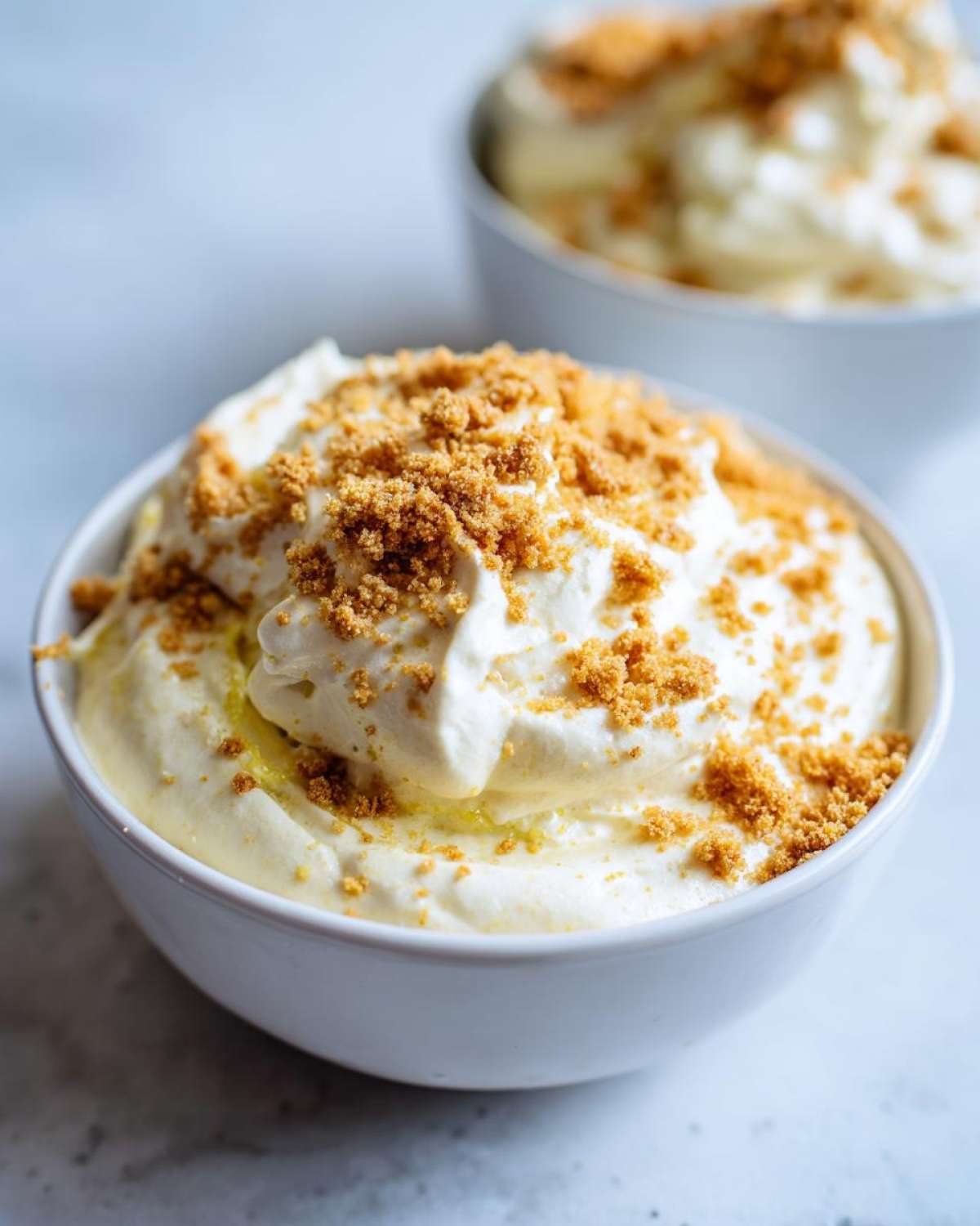 Close-up of creamy Banana Cream Pie Blended Chia topped with graham cracker crumbs in a white bowl.
