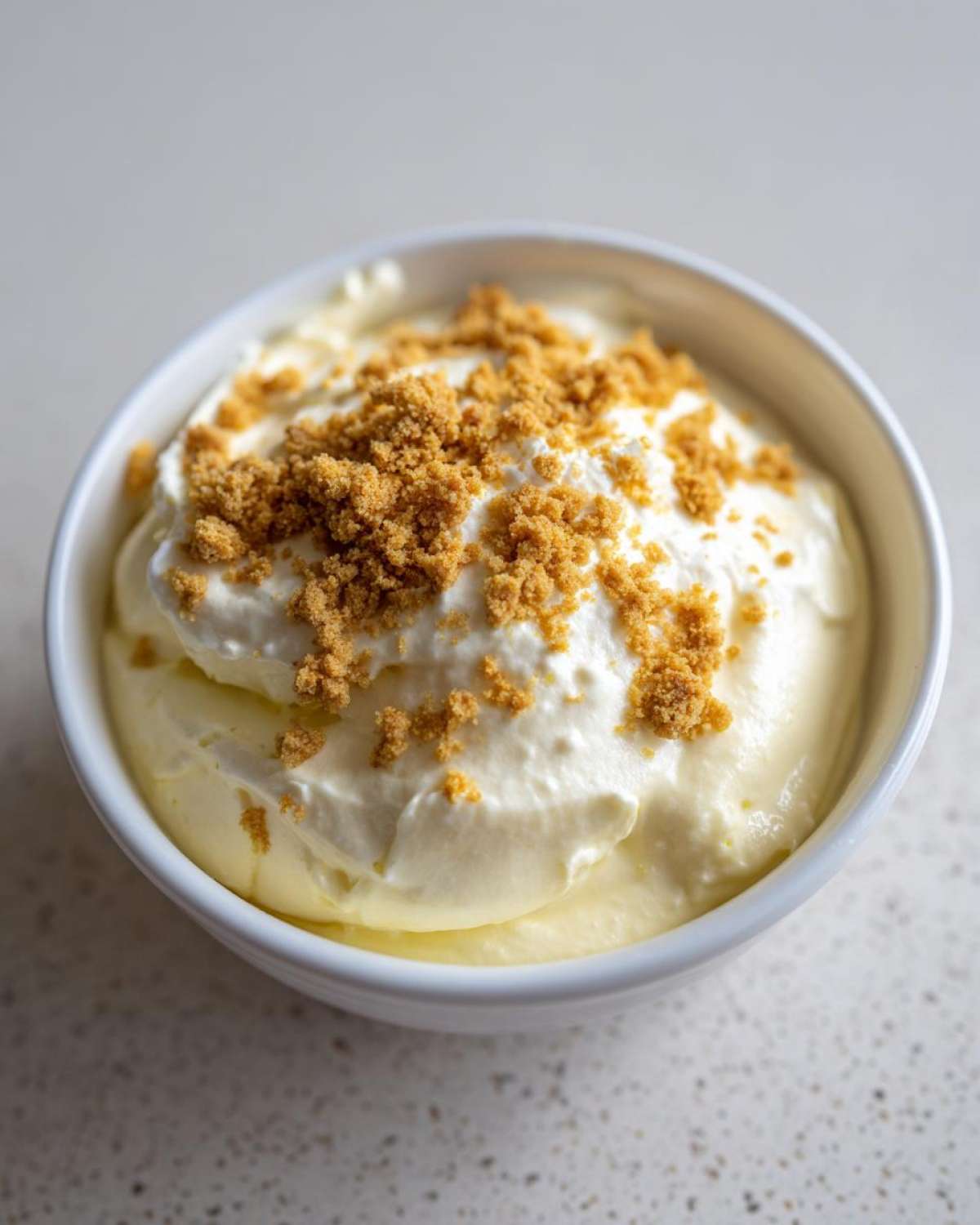 Close-up of Banana Cream Pie Blended Chia pudding topped with whipped cream and graham cracker crumbs.