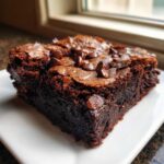 A close-up of an irresistibly chewy brown butter brownie slice topped with chocolate chips.