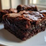Close-up of a rich, fudgy brownie square showing a shiny, crackly top crust, illustrating the desired texture when fixing Brownies Missing That Fudgy Texture.