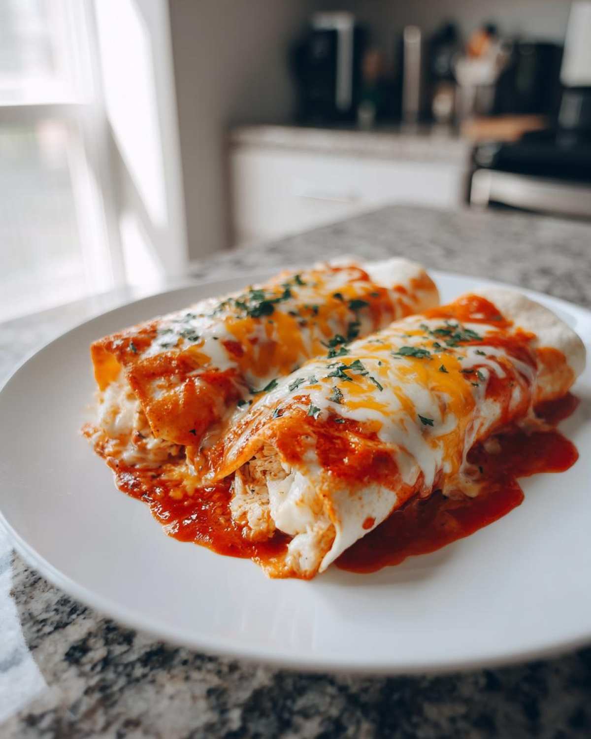Two delicious Joanna Gaines Enchiladas covered in melted cheese and red sauce, garnished with parsley.