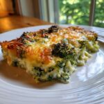 A close-up serving of rich Keto Broccoli Au Gratin with a golden, bubbly cheese crust.