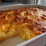 Close-up of a baked Keto Broccoli Cauliflower Au Gratin with a bubbly, golden-brown cheesy crust in a white baking dish.