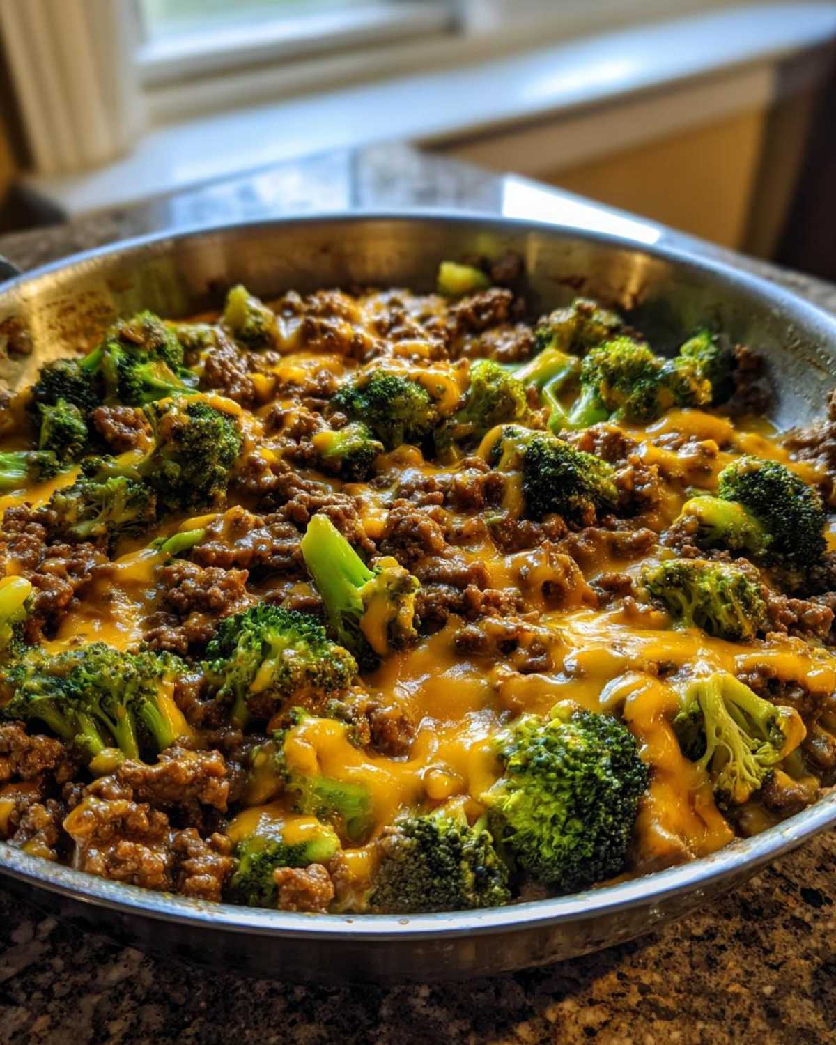 Close-up of a Keto Hamburger Broccoli Skillet with melted cheddar cheese over ground beef and bright green broccoli florets.