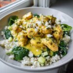 Close-up of a Low Carb Lemon Dill Chicken Bowl featuring creamy chicken over cauliflower rice, spinach, and crumbled feta.