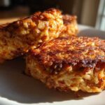 Close-up of two golden brown, crispy Oven-Baked Cabbage Burgers stacked on a white plate.