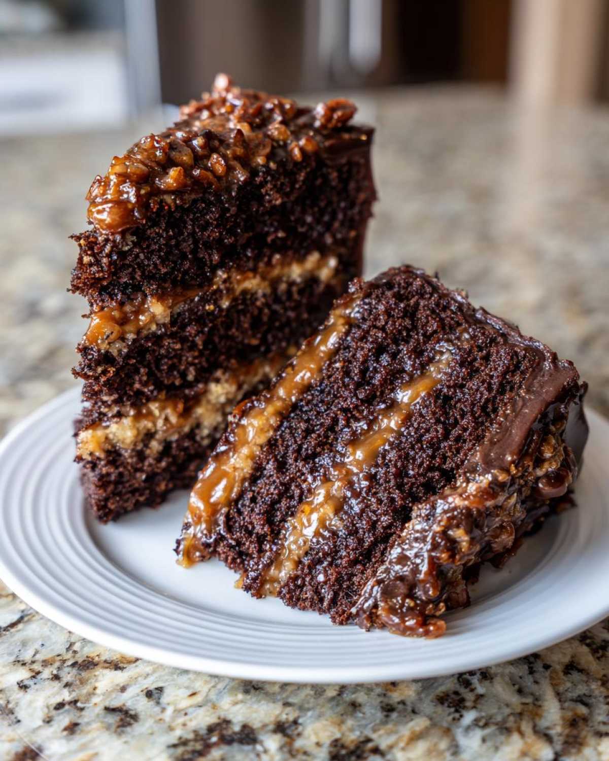 Two decadent slices of german chocolate cake recipe showing dark chocolate layers and gooey coconut-pecan filling.