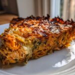 A close-up slice of Whole30 BBQ Chicken Casserole showing shredded chicken and sweet potato layers with a dark, crispy top.