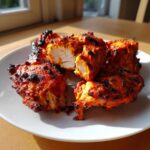 Close-up of perfectly cooked Baked Tandoori Chicken Oven pieces, showing charred edges and moist white interior.