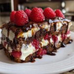 A rich slice of chocolate layer cake with cream filling, fresh raspberries, and chocolate drizzle, perfect for Desserts Bring Any Party magic.