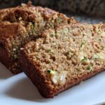 Close-up of a sliced loaf of Easy Apple Cinnamon Zucchini Bread showing moist crumb, apple chunks, and green zucchini flecks.