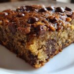 Close-up of a moist slice of Easy Bakerystyle Chocolate Chip Banana bread on a white plate.