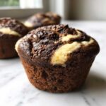 A close-up of one of the Easy Chocolate Cream Cheese Muffins showing the marbled chocolate cake and cream cheese swirl.