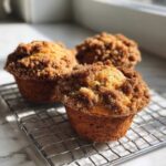 Three Easy Coffee Cake Muffins Deliciously Great cooling on a wire rack with a crumbly cinnamon topping.