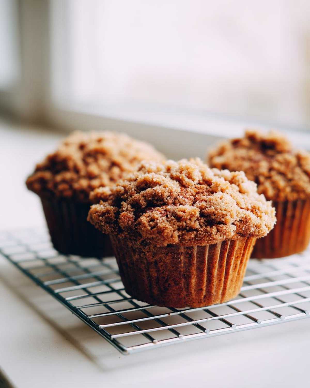 Three Easy Coffee Cake Muffins Deliciously topped with thick cinnamon streusel cooling on a wire rack.