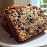 Close-up of two slices of Easy Decadent Oreo Banana Bread showing moist crumb and chocolate chunks on a white plate.