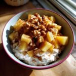 Close-up of an Easy Healthy Apple Cinnamon Greek bowl topped with warm apples, walnuts, and cinnamon.