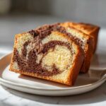 Close-up of three slices of Easy Irresistible Marble Loaf Cake showing the beautiful vanilla and chocolate swirl pattern.