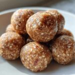 Close-up of a stack of Easy Snack Smarter High Protein energy balls on a white plate.