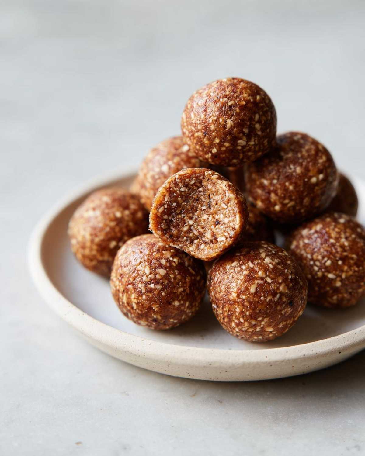 A stack of homemade energy balls, perfect for an Easy Snack Smarter High Protein option, with one cut in half showing the texture.