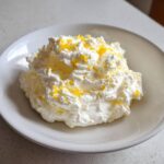 A dollop of fluffy Easy Soft Lemon Cream Cheese topped with bright yellow lemon zest.