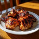 Close-up of juicy, charred pieces of Grilled Vietnamese Chicken served on a white plate.