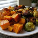 Close-up of roasted butternut squash cubes and Brussels sprouts, key ingredients for the Cranberry Glazed Roasted Butternut Squash Brussels Sprouts and Sweet Potato Salad.
