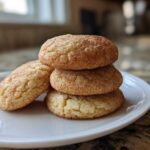 A stack of three soft chewy Banana Snickerdoodle Cookies coated in cinnamon sugar on a white plate.