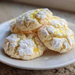 A stack of Soft Lemon Lavender Cookies Floral, dusted heavily with powdered sugar and topped with bright yellow lemon zest.