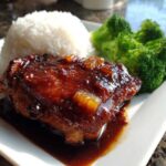 A serving of glazed Teriyaki Pineapple Chicken Thighs next to white rice and steamed broccoli florets.
